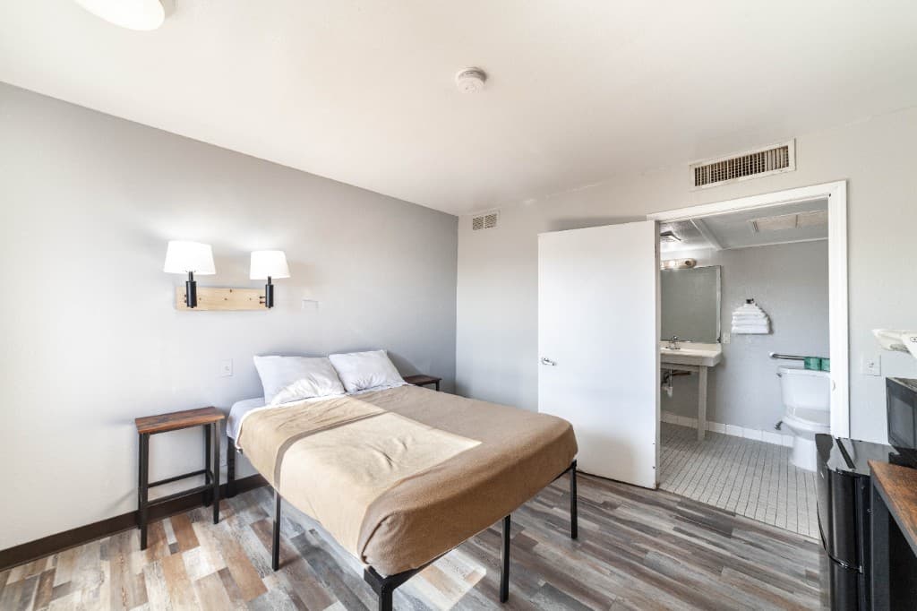 Guest room with a bed, mini fridge, and microwave